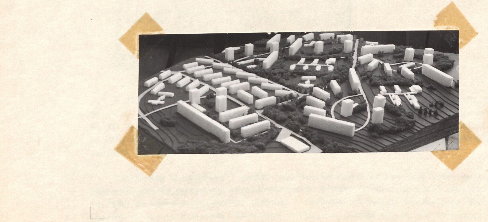 Černobílá fotografie architektonického modelu (maketa) plánované komplexní dostavby Horního Slavkova – bílé modely panelových obytných domů (5–11 podlažních), komunikace a zeleň; pohled shora. Bez vepsané popisky, vedle vpravo jen tužkou značka „F".