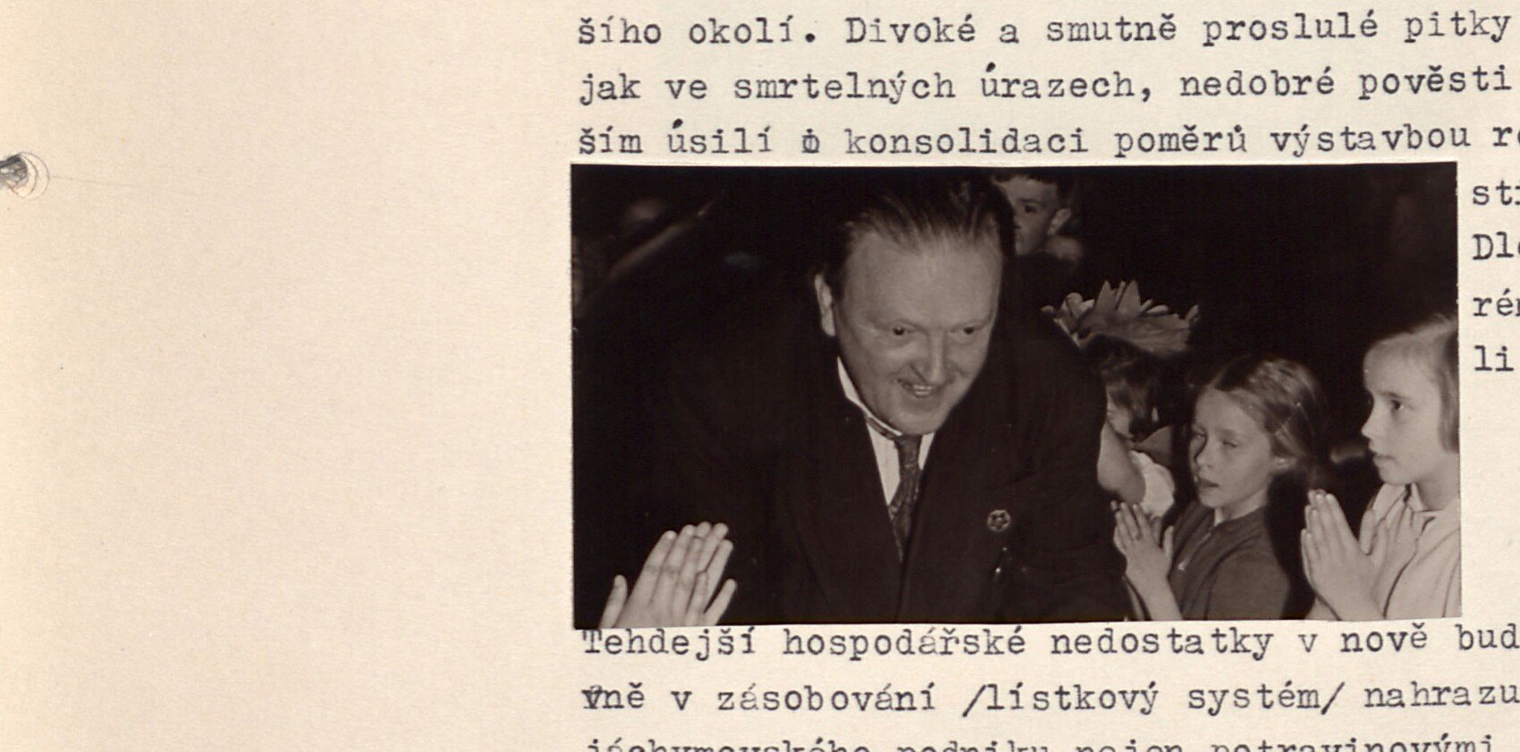 Černobílá fotografie: usmívající se muž (tleská) obklopený dětmi — pravděpodobně s. A. Turek, "strýček Turek". Bez tištěné popisky.