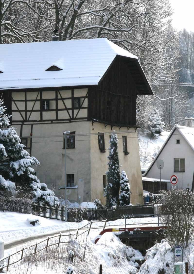 Zasněžený zimní pohled na hrázděný dům u potoka na okraji města (Slavkovský zpravodaj, 1/2015)