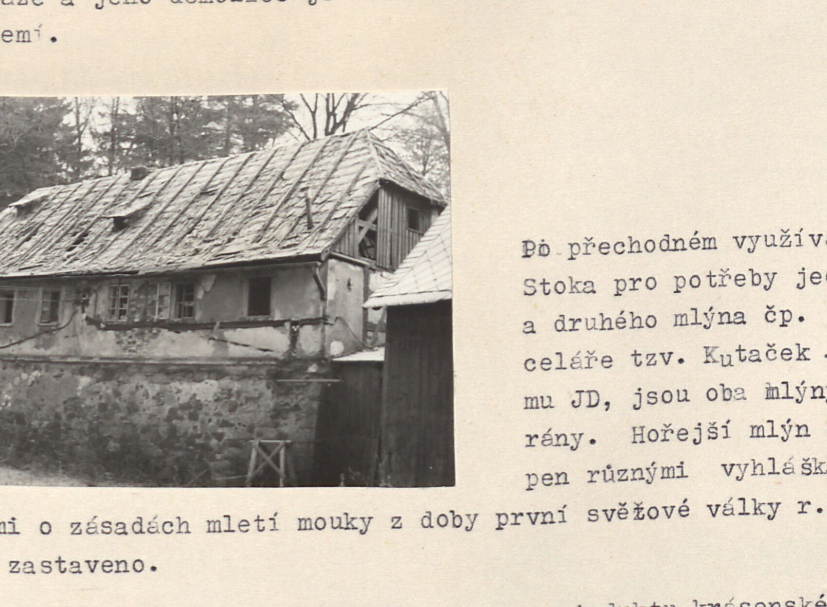 Starý dřevěný (roubený) mlýn na potoce Stoka se šindelovou střechou, obklopený lesem.
