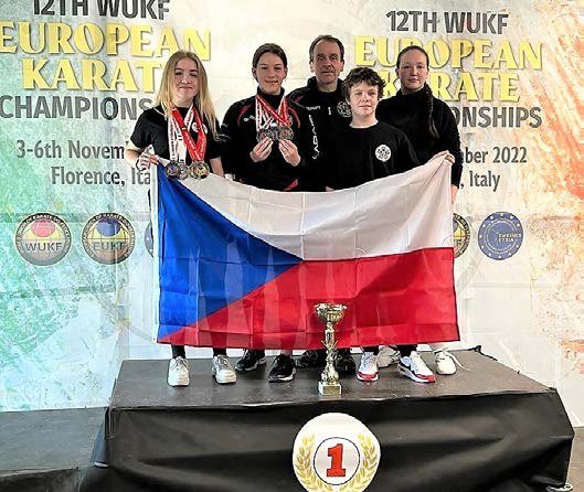 Slavkovští karatisté s českou vlajkou a trofejí (Slavkovský zpravodaj, 2/2023)