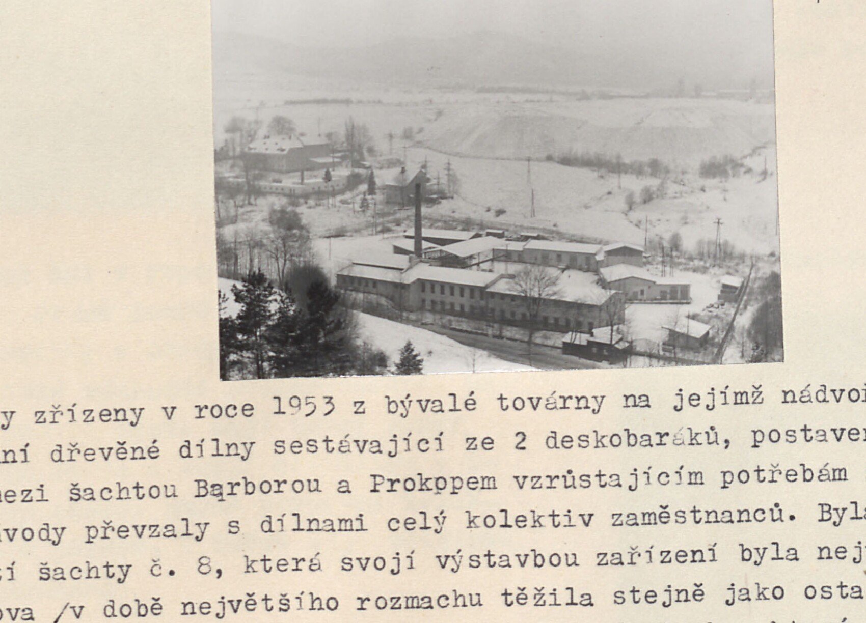 Zimní pohled na bývalou továrnu (Ústřední dílny JD / Stalinovy závody) při silnici do Krásna, zasněžená krajina s tovární budovou a komínem; v rohu rukou připsáno "F".