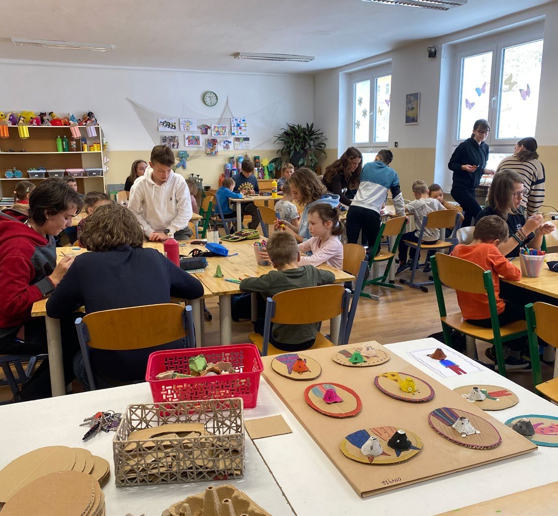 Posezení účastníků u stolů na společenské akci (Slavkovský zpravodaj, 1/2024)