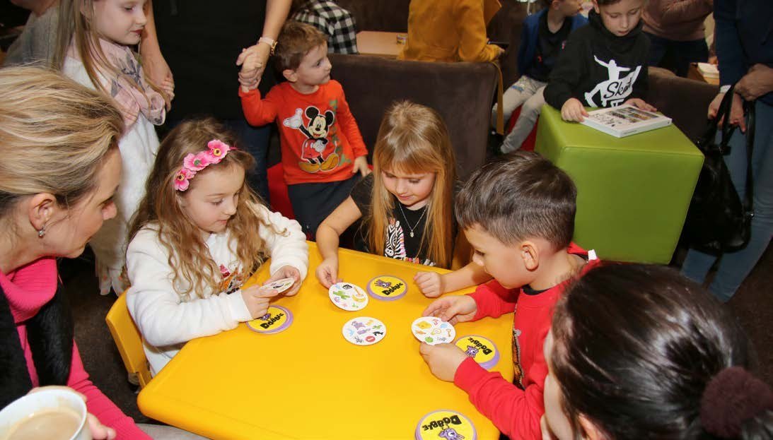 Účastníci v maskách u stolů na maškarním reji (Slavkovský zpravodaj, 2/2020)