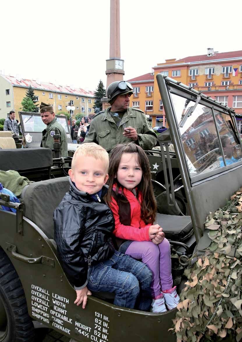Děti v historickém vojenském vozidle při oslavách Dne osvobození na náměstí (Slavkovský zpravodaj, 6/2012)