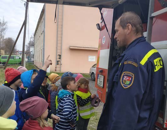 Hasič předvádí dětem techniku při exkurzi na hasičské stanici (Slavkovský zpravodaj, 6/2022)