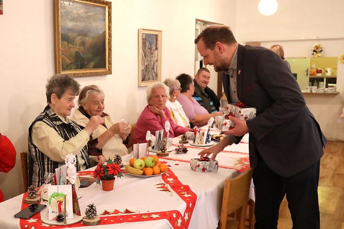 Vánoční posezení seniorů u slavnostně prostřeného stolu (Slavkovský zpravodaj, 1/2024)