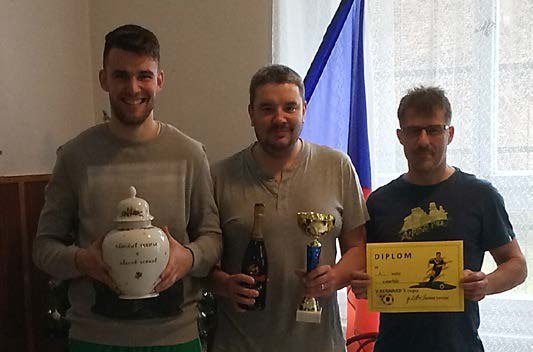 Mladí sportovci s pohárem před vlajkou (Slavkovský zpravodaj, 2/2016)