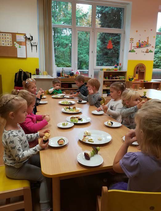 Posezení seniorů u stolů na společenské akci (Slavkovský zpravodaj, 11/2019)
