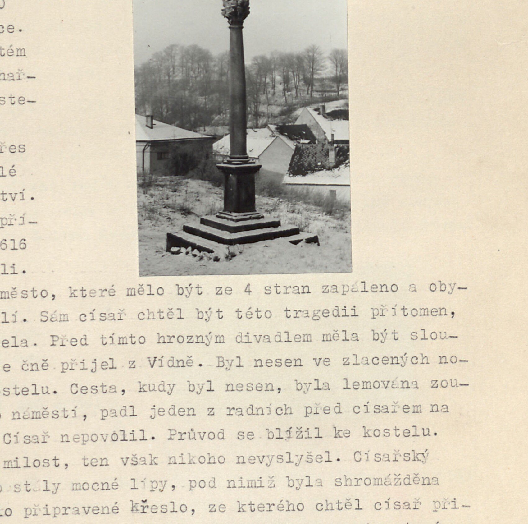 Barokní mariánský (trojiční) sloup zasvěcený kultu Trojice, postavený kolem roku 1700, v zimě, nad ním v pozadí zasněžená krajina a střechy města
