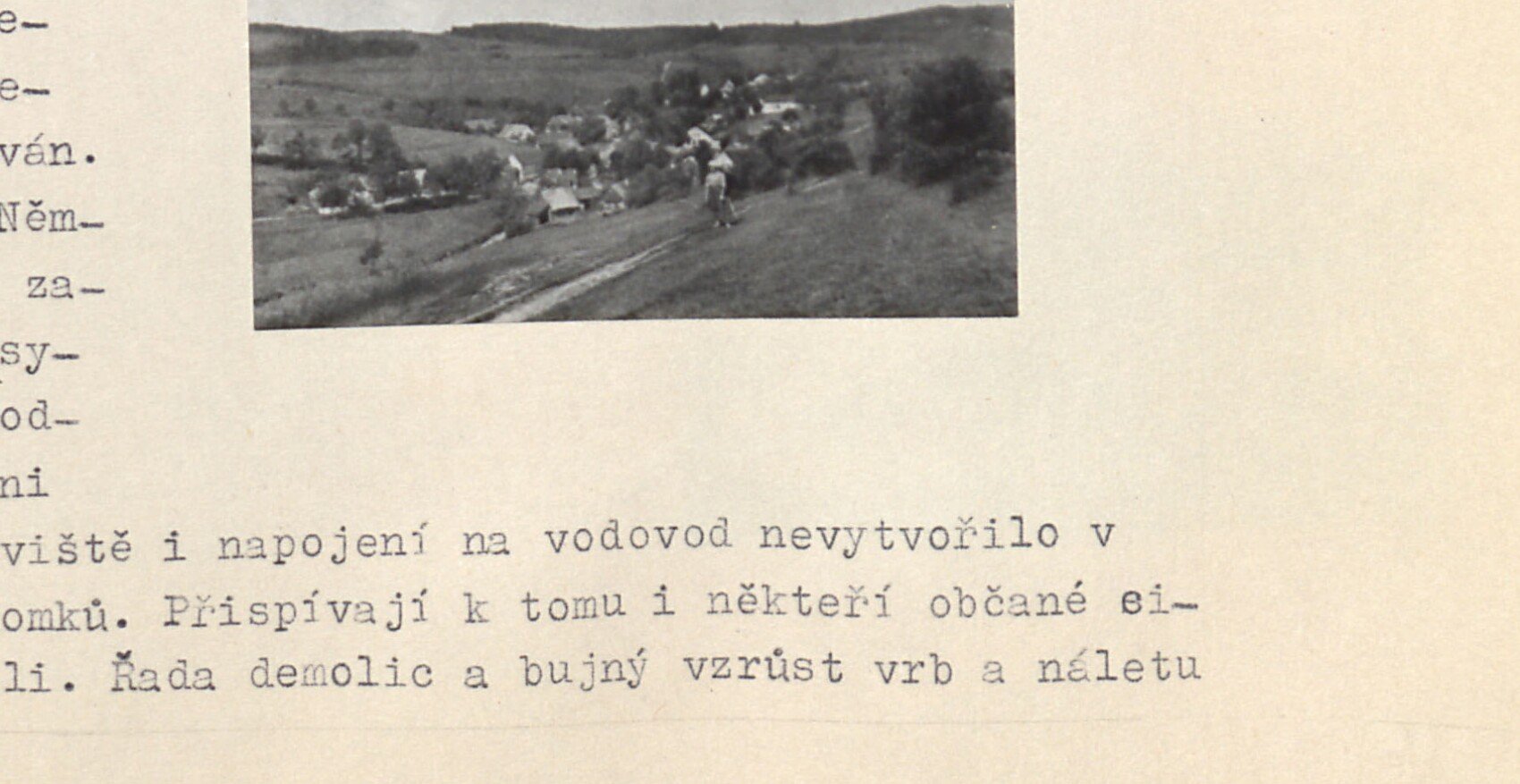 Panoramatický pohled na vesnici Bošířany v krajině s poli a kopci