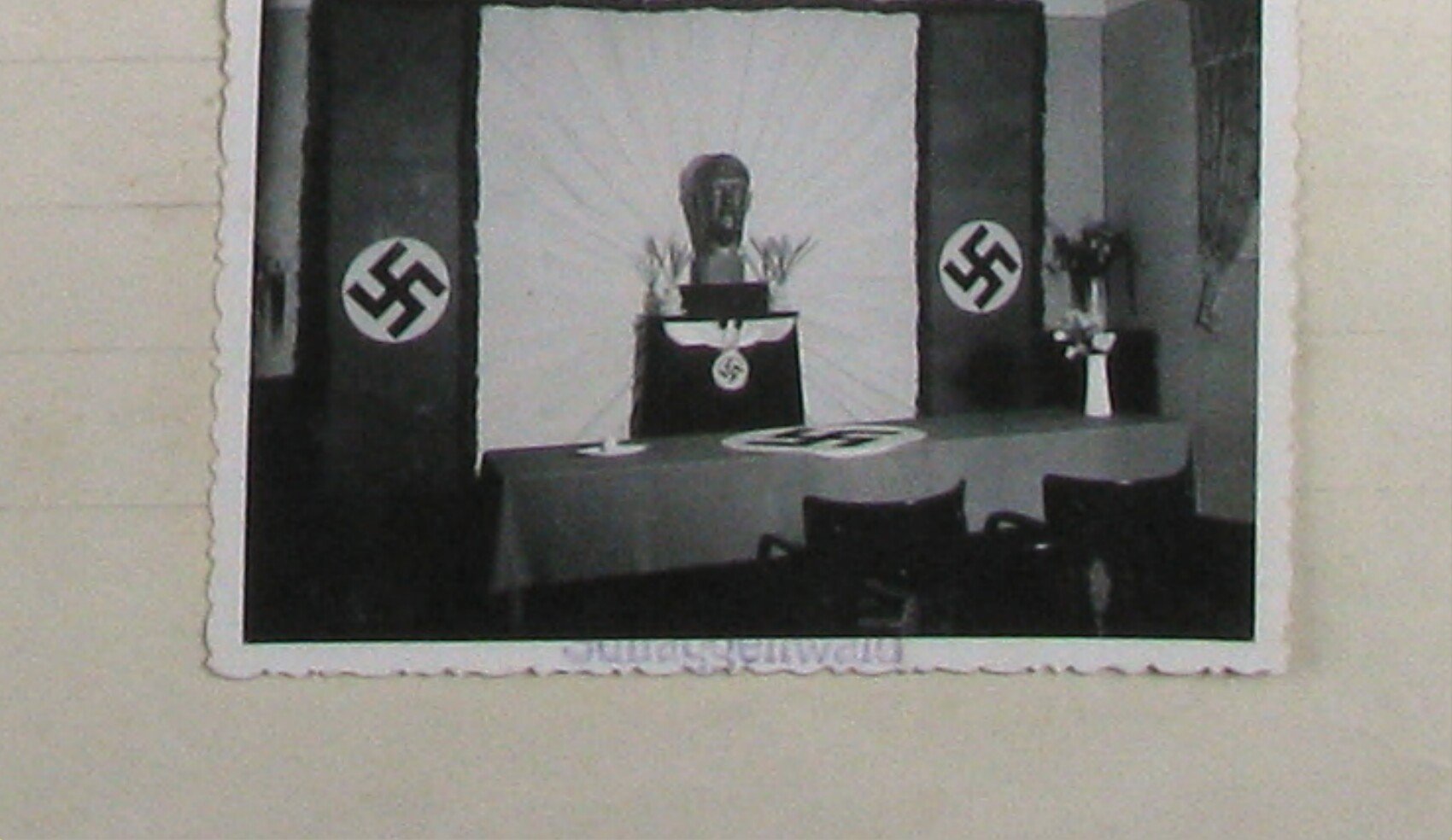 Výstava / výbava matričního úřadu (Standesamt) 1941: stůl s prapory s hákovými kříži, uprostřed busta; popiska „Standesamt 1941"