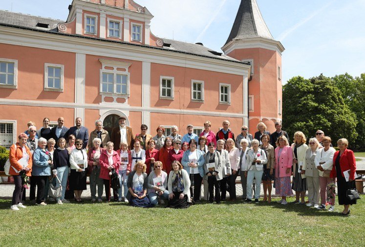 Společné foto účastníků – senioři před zámkem (Slavkovský zpravodaj, 6/2025)