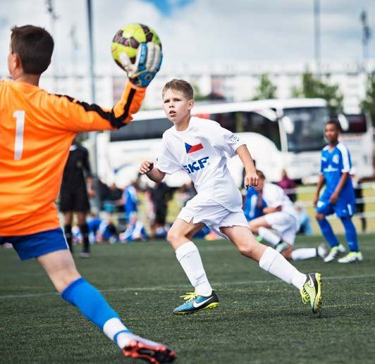 Mladí fotbalisté v zápase, brankář chytá míč (Slavkovský zpravodaj, 9/2016)
