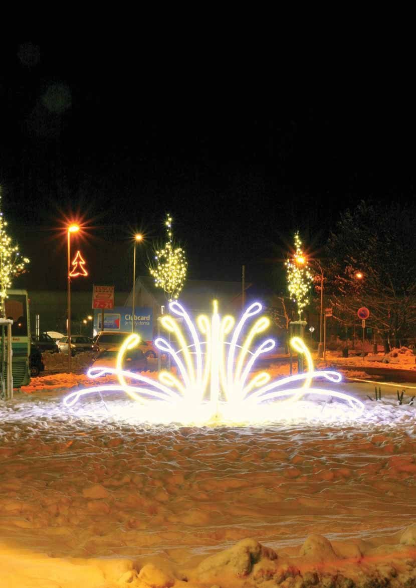 Večerní pohled na náměstí s vánočně nasvícenými stromy a světelnou fontánou (Slavkovský zpravodaj, 1/2013)
