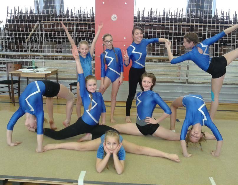 Mladé gymnastky v dresech při společné pozici v tělocvičně (Slavkovský zpravodaj, 4/2016)