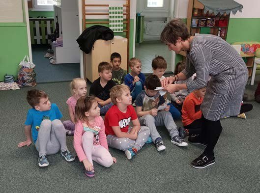 Děti se zaměstnankyní školky při společné aktivitě (Slavkovský zpravodaj, 1/2022)