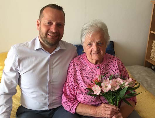 Starosta Alexandr Terek blahopřeje jubilantce s květinami (Slavkovský zpravodaj, 9/2019)
