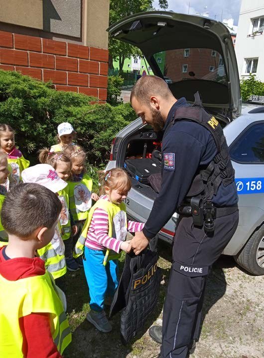Beseda policisty s dětmi u policejního vozu na Dni dětí (Slavkovský zpravodaj, 7/2022)